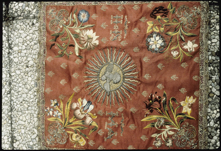 Voile de calice : satin rouge brodé de fleurs en fils de soie de différentes couleurs, motif central représentant la colombe de l'Esprit Saint, brodé de fils d'argents, bordure agrémentée d'une résille en fils d'argent - © Ministère de la Culture (France), Médiathèque du patrimoine et de la photographie, diffusion RMN-GP