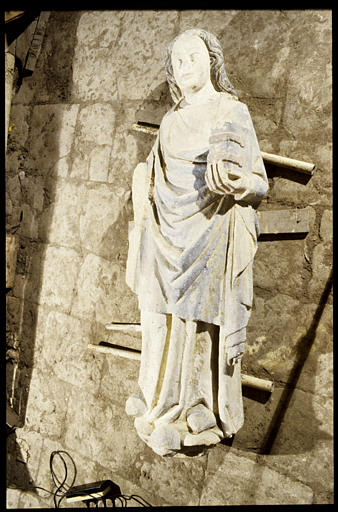 Statue : Apôtre (?), personnage en demi-relief tenant un livre fermé dans la main gauche