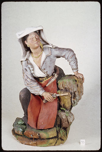 Statue : statuette de femme en costume espagnol, embusquée derrière un rocher, tenant un pistolet dans la main droite, terre cuite peinte, d'un ensemble de 16