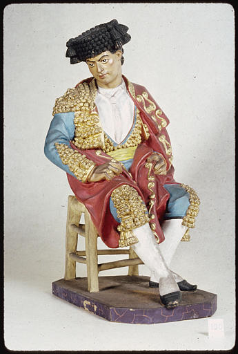 Statue : statuette de toréador assis sur un tabouret, l'air pensif, terre cuite peinte, d'un ensemble de 16