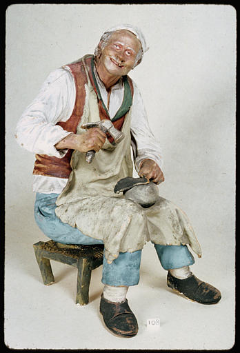 Statue : statuette d'un cordonnier en costume espagnol, assis sur un tabouret bas, terre cuite peinte