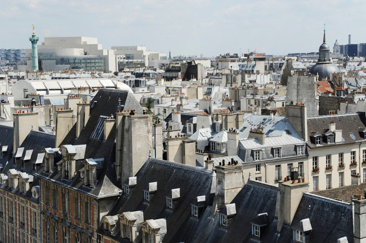 Toits de Paris au-dessus de la place des Vosges. L'opéra Bastille et le dôme du temple du Marais