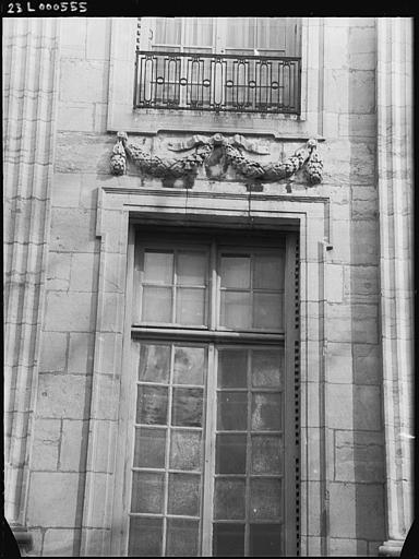 Façade sur jardin : fenêtre surmontée d'une guirlande ornementale