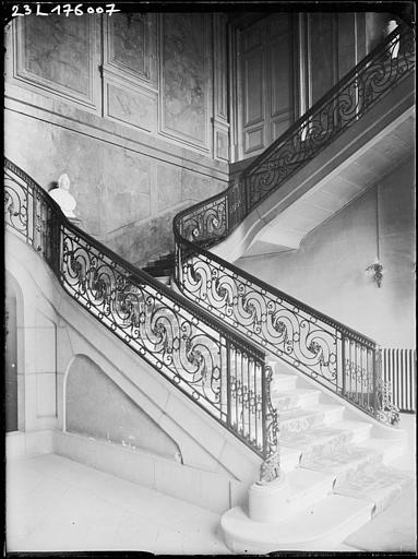 Intérieur : vue latérale de l'escalier et rampes en fer forgé