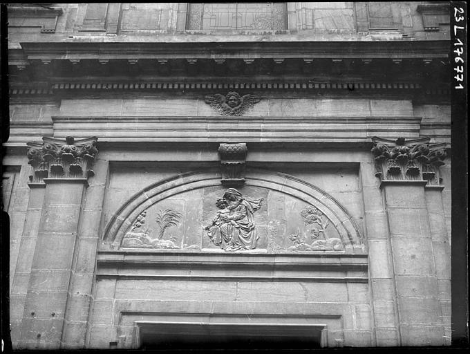 Chapelle, détail de la façade : Vierge à l'enfant sculptée en bas-relief au-dessus du portail