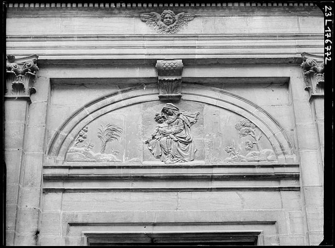 Chapelle, détail de la façade : Vierge à l'enfant sculptée en bas-relief au-dessus du portail