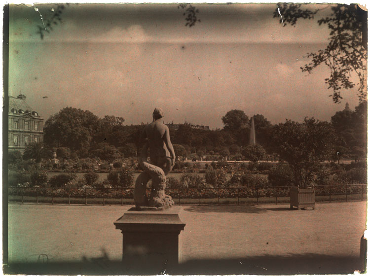 Jardins fleuris, la Vénus au Dauphin de dos au premier plan, le palais en arrière-plan à droite