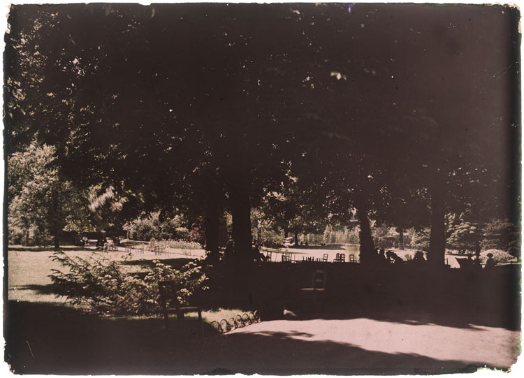 Vue général du jardin, des personnes installées à l'ombre des arbres