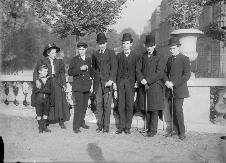 Jean Antoine et ses amis dandys en chapeaux marins et chapeaux melon, accompagnés de Marthe Antoine et d'un petit garçon