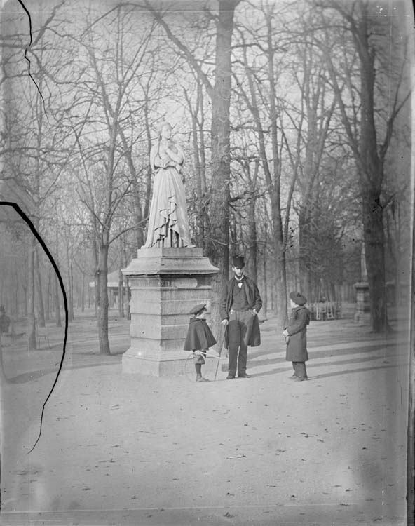 Jean et un homme portant un chapeau haut de forme devant la statue de Marguerite d'Angoulême