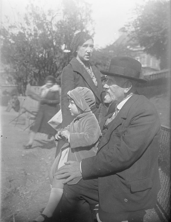 Jules Antoine sur un banc, sa petite-fille Anne sur les genoux, sous le regard de Marthe