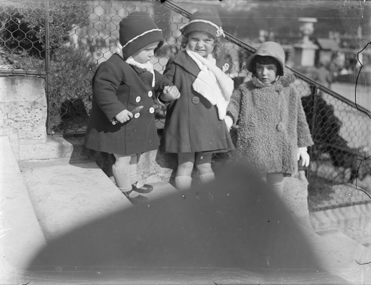 Anne, Agnès et une fillette en habits d'hiver posant sur les marches d'un escalier