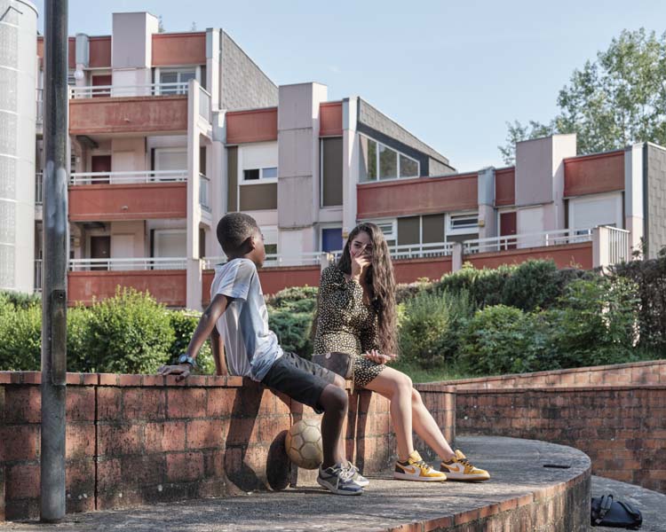 Jeunes gens dans un amphithéâtre extérieur, ligne de bâtiments à l’arrière-plan