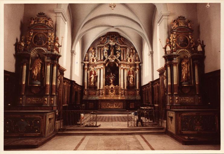 vue intérieure de l'église avec le retable du maître-autel et les deux autels latéraux, après restauration