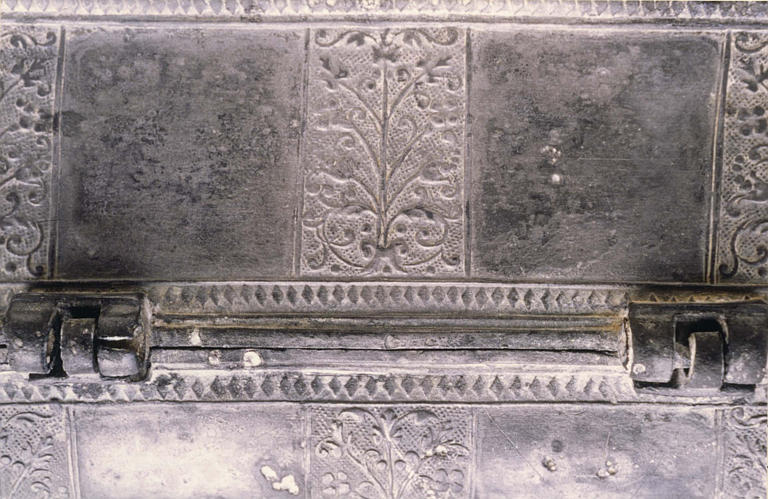 Coffret aux saintes huiles : détail du décor de rinceaux et des frises de losanges, étain
