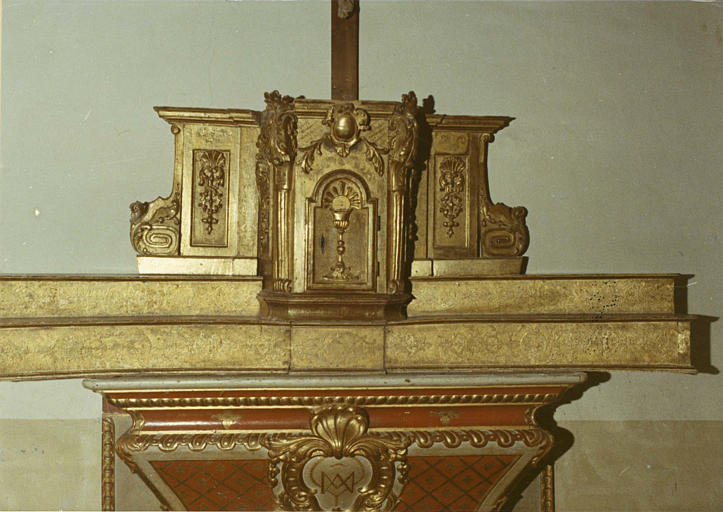Tabernacle composée d'une partie en ressaut flanquée de deux panneaux sculptés et de deux volutes, décor sculpté de motifs végétaux et d'un calice avec une hostie rayonnante, bois sculpté, doré - © Ministère de la Culture (France), Médiathèque du patrimoine et de la photographie (objets mobiliers), tous droits réservés