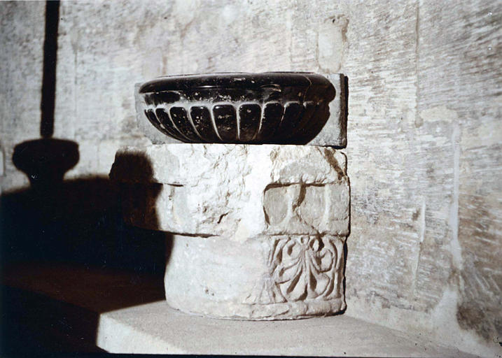 Chapiteau : fragment en pierre sculptée d'une palmette, servant de support à un bénitier