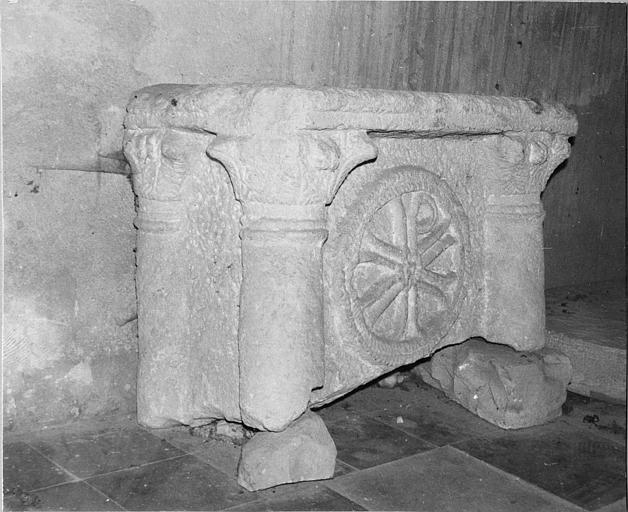 Autel en pierre, sculpté de quatre colonnes à chapiteaux feuillagés et du chrisme