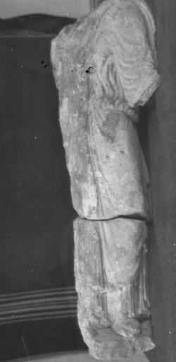 statue : roi en prière, trouvée en 1952 (provient de l'ancienne abbaye de Saint-Père), vue de dos, le vêtement passe sur l'épaule gauche et retombe sur le dos, gros plissements à la taille