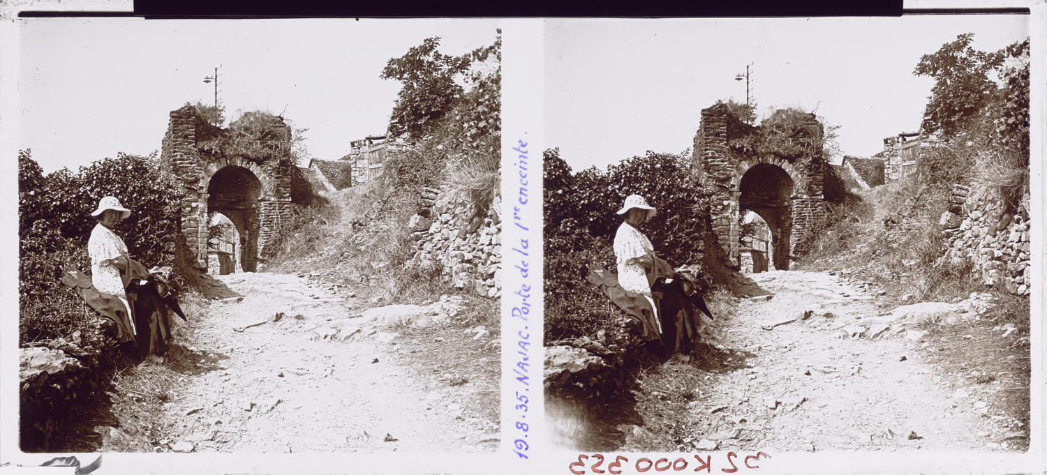 Femme posant sur un muret près des ruines de la porte