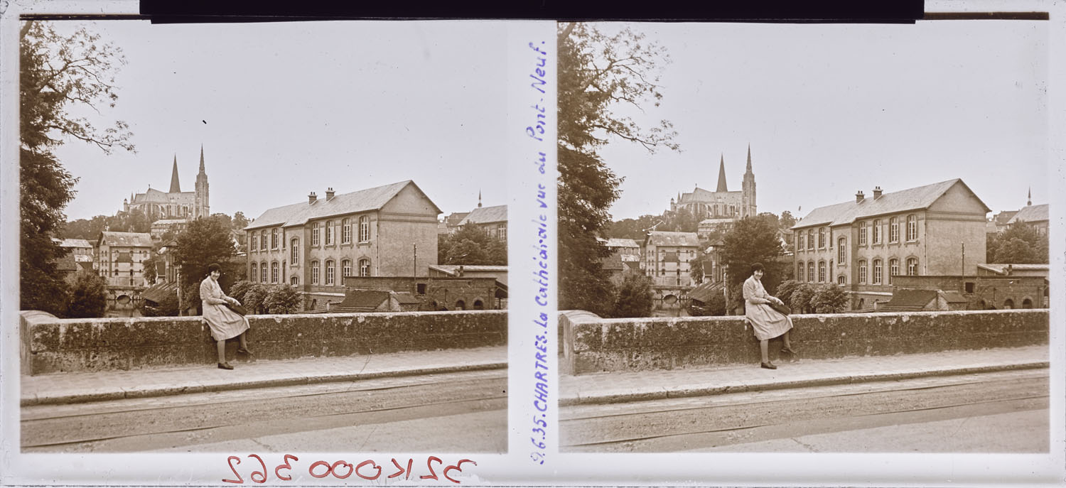 Femme assise sur la rambarde d’un pont, la cathédrale en arrière-plan