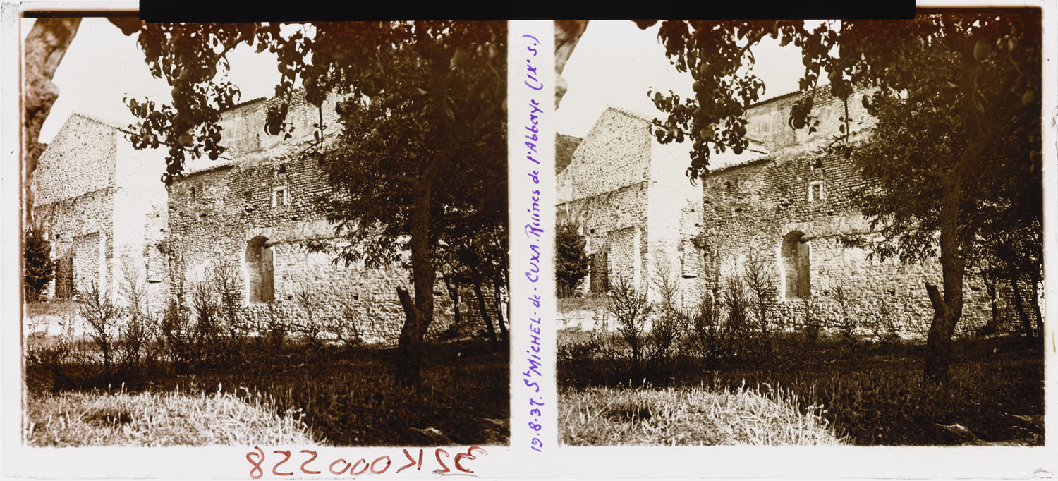 Bâtiments de l’ancienne abbaye aperçus à travers des frondaisons