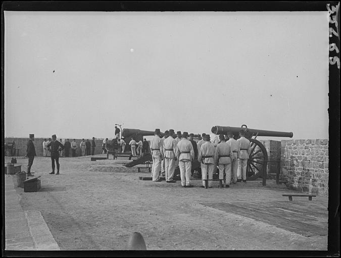 Sur les remparts de l'enceinte fortifiée, pièces d'artillerie en batterie, vers l'eau : réglages, gros plan