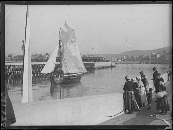 Entrée au port d'un voilier de pêche immatriculé DI 106, hommes et femmes sur le quai