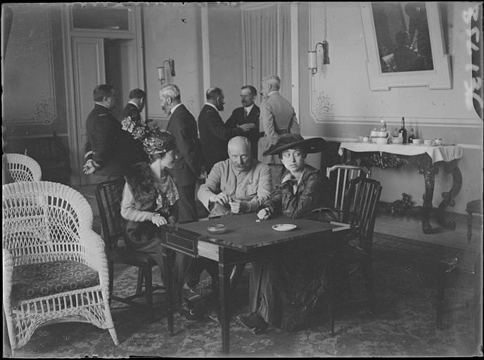 Politique Albanaise (supposée), salon : trois personnes assises à table, au fond le colonel de Stael, M. Boppe, un officier, M. Lorgeau secrétaire de M. Boppe et deux officiers