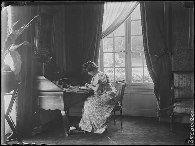 Scène de genre, intérieur, salon : jeune femme assise à un bureau, écrivant une lettre