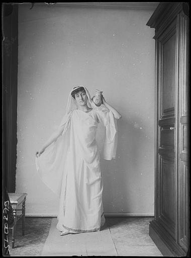 Portraits de Marcelle ou Suzanne en costume péplum : débout, de face, portant un vase sur une épaule