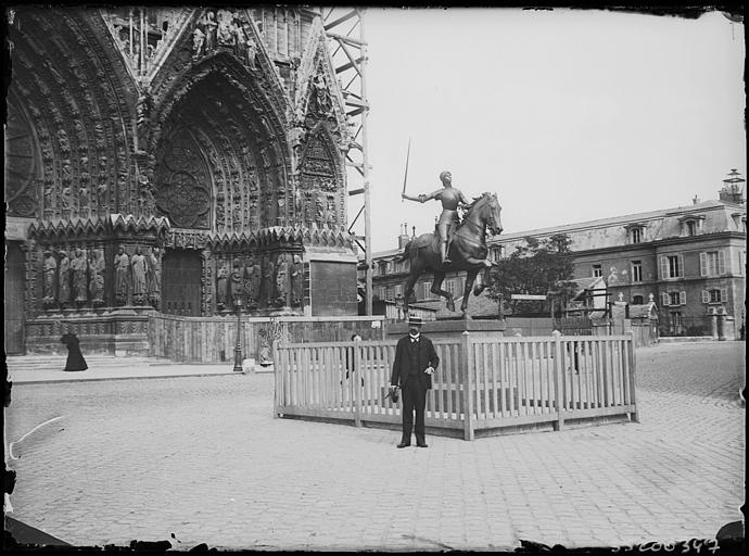 Partie de la façade principale et parvis avec statue équestre de Jeanne d'Arc : homme en pose devant