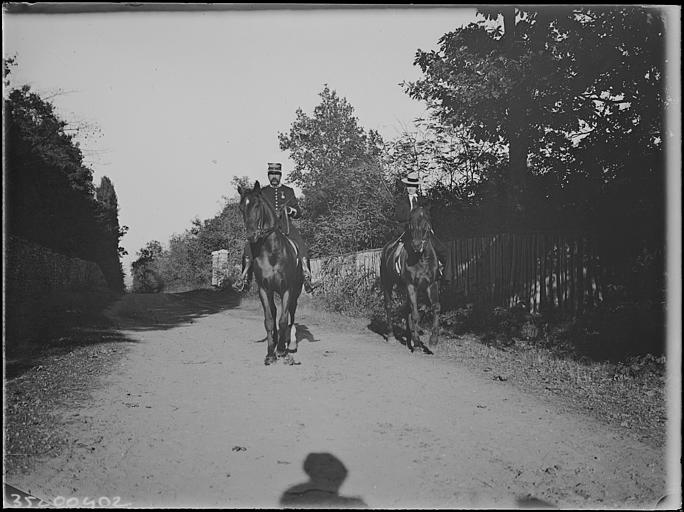 Allée forestière : portrait d'un officier du 18e Régiment de cavalerie, à cheval, et cavalière en amazone