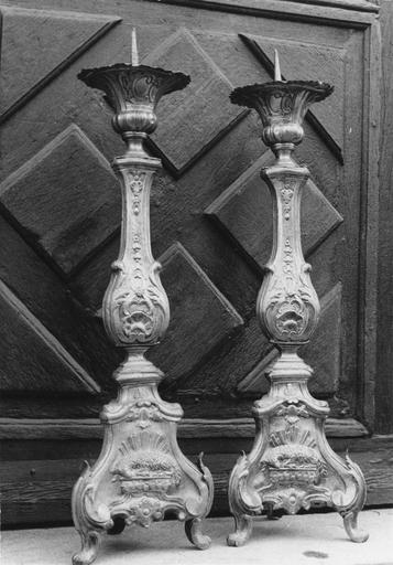 Deux chandeliers d'autel, d'un ensemble de six, au pied orné de l'Agneau immolé et aux bobèches en forme de corolles évasées, décor de motifs végétaux, cuivre - © Ministère de la Culture (France), Médiathèque du patrimoine et de la photographie (objets mobiliers), tous droits réservés