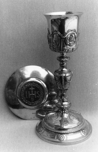 Calice à décor de réserves aux grappes de raisin, épis de blé et croix, de guirlandes de laurier et de branches de roseau, patène gravée du monogramme IHS et de la couronne d'épines, argent doré