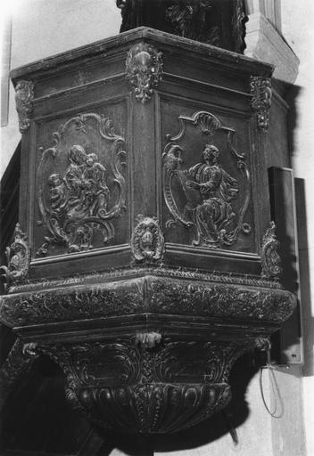 Chaire à prêcher : détail du garde-corps de tribune, à panneaux sculptés en bas-relief d'une Vierge à l'Enfant et de saint Jean l'évangéliste, angles ornés de cartouches, bois sculpté