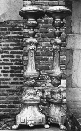 Deux chandeliers d'autel, d'un ensemble de six, à tiges en forme de colonnes à chapiteaux ioniques garnis de tissu drapé, décor de grappes de raisin et épis de blé noués, motifs de feuilles d'acanthe et motifs géométriques, cuivre
