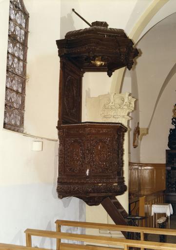 Chaire à prêcher richement ornée de nombreux motifs végétaux et de médaillons, à l'effigie des quatre évangélistes et de la Vierge à l'Enfant sur la tribune, et de saint Michel sur le dorsal, bois sculpté, doré ; avant restauration - © Ministère de la Culture (France), Médiathèque du patrimoine et de la photographie (objets mobiliers), tous droits réservés