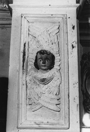 Retable : détail d'une base de colonne sculptée d'un séraphin en bas-relief, bois sculpté, peint