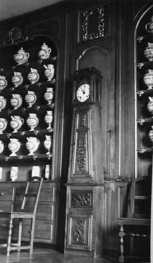 Horloge au sol à gaine pyramidale, au décor sculpté de motifs végétaux et d'un trophée d'instruments de musique, bois taillé