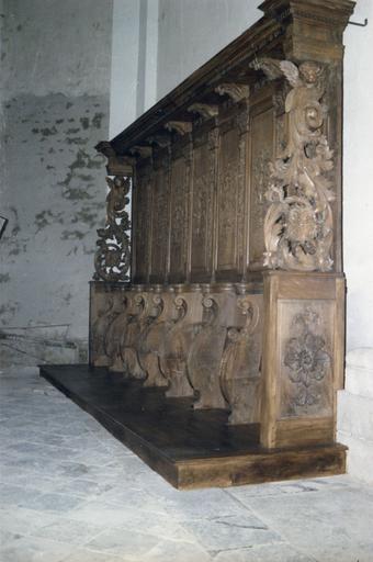 Lambris de revêtement, stalles : panneaux sculptés de bouquets de fleurs ou de volutes végétales, séparés par des pilastres à chutes de feuilles et chapiteaux corinthiens, les extrémités sont sculptées d'un gros rinceau végétal surmonté d'un chérubin, boi