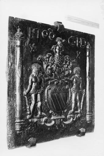 Plaque de cheminée aux armes d'une famille entourées de trois personnages barbus armés de massues, datée de 1708, fonte