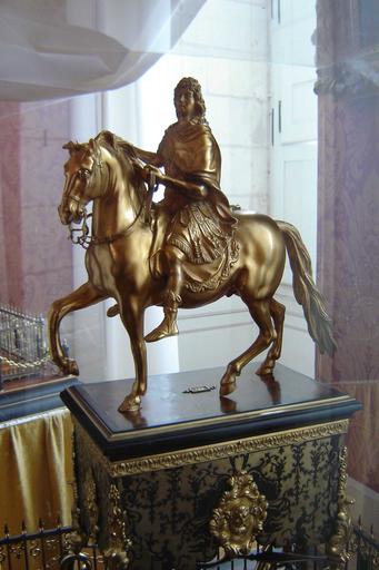 statue, socle, piédestal : portrait équestre de Louis XIV sur socle en marqueterie d'écaille et de laiton, sur un piédestal en bois encadré de grilles en fer et laiton, et de chaînes