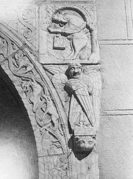 Maison abbatiale : portail sculpté, détail de l'écoinçon droit orné d'un taureau symbolisant saint Luc et d'un séraphin (tympan transféré dans la galerie du cloître)