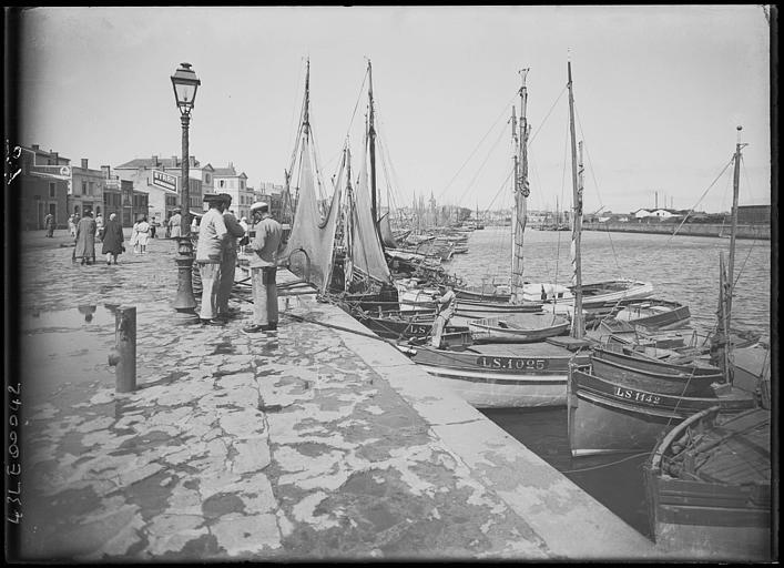 A quai, trois hommes et bec de gaz