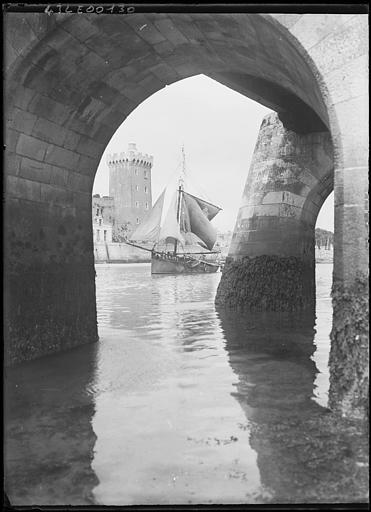 Sous la jetée, barque sortant avec manoeuvre des voiles