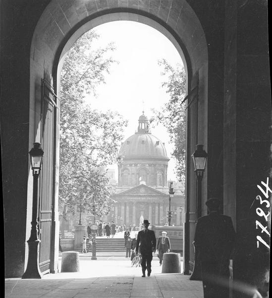 [L'Institut de France et la passerelle des Arts depuis une arche des guichets du Louvre]