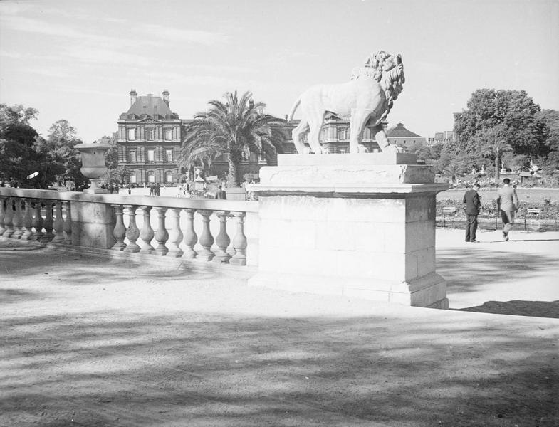 [La statue de Lion de Jean-Baptiste Henraux, des promeneurs au parc du Luxembourg]