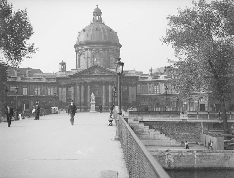 [Vue d'ensemble de la façade sur la passerelle des Arts ; passants]