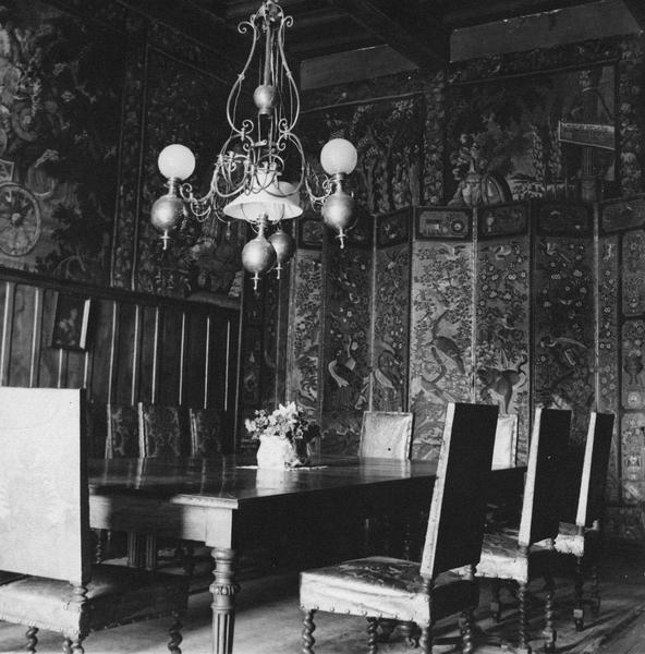 salle à manger avec deux tableaux de tapisserie et une table avec dix chaises